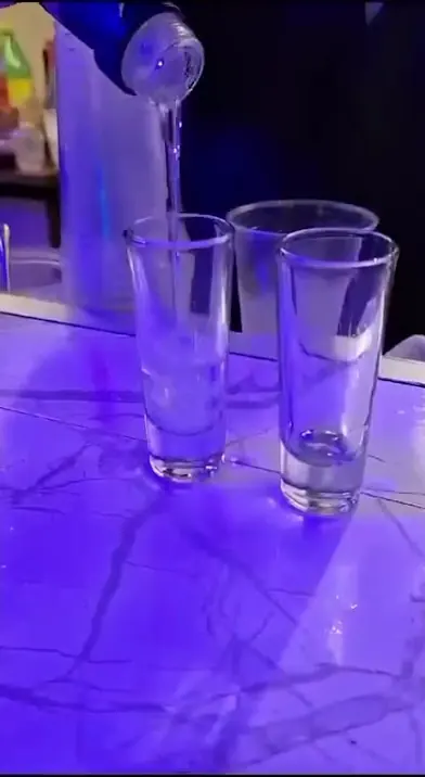 Bartender de Drink In Car sirviendo shots en la barra iluminada